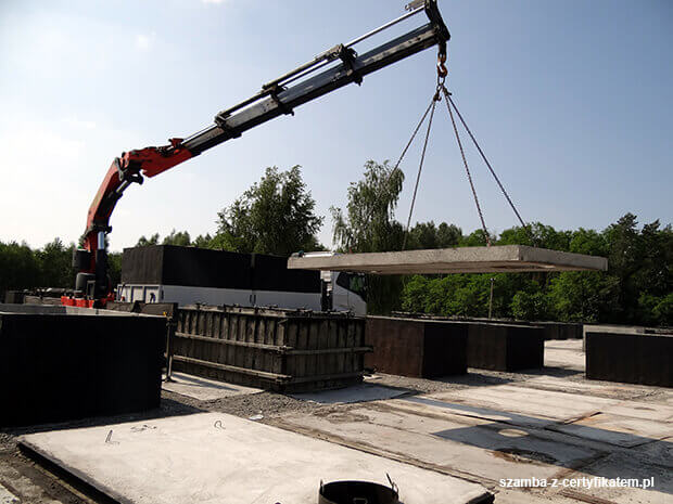 Załadunek szczelnego szamba betonowego do transportu  w Giżycku